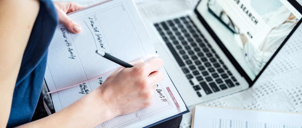 Close-up of a young woman searching for internships on her laptop and writing an application for an internship.