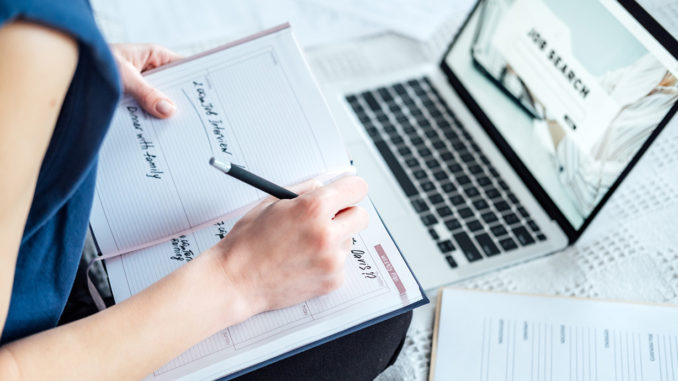 Close-up of a young woman searching for internships on her laptop and writing an application for an internship.