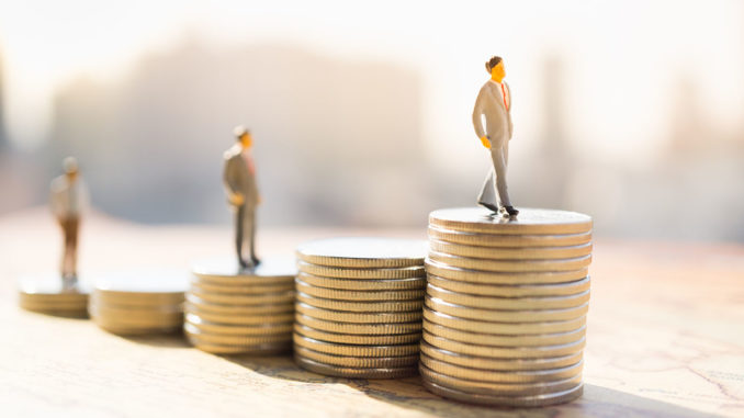 Miniature,People:,Small,Figure,Standing,On,Stack,Of,Coin.,Money Miniature figures standing on stacks of coins of different heights