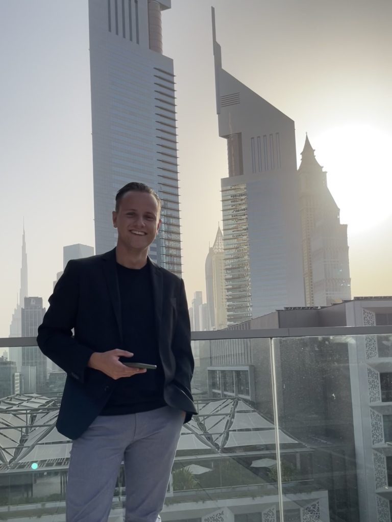Elias Scholz, student of Munich Business School in front of a Dubai skyline during his semester abroad in Dubai