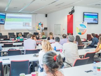 Multiplier Event of the "Conscious Business Education" Research Project in Barcelona; speakers on stage and participants from behind in the audience