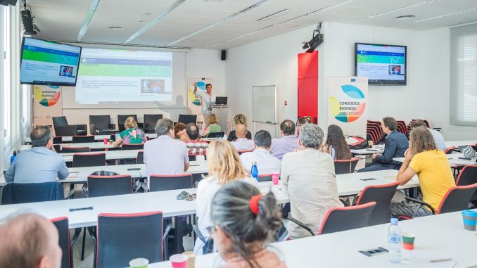 Multiplier Event of the "Conscious Business Education" Research Project in Barcelona; speakers on stage and participants from behind in the audience