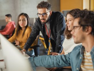 A group of students discussing their start-up projects on the computer.