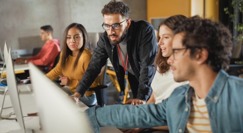 A group of students discussing their start-up projects on the computer.