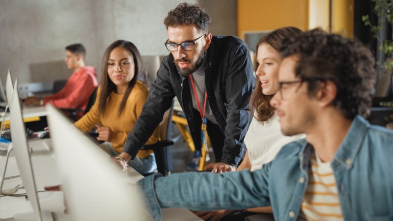 A group of students discussing their start-up projects on the computer.